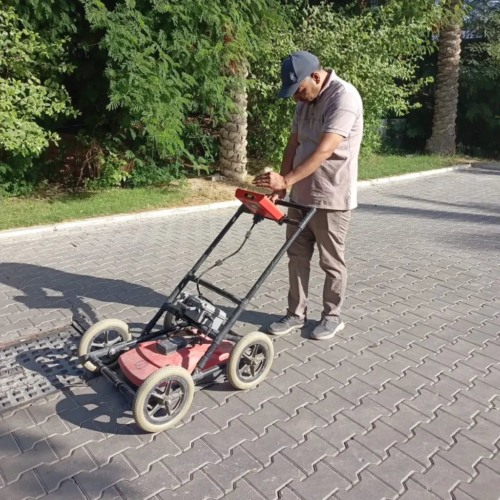 Ground-penetrating radar cart being run across the paved survey area