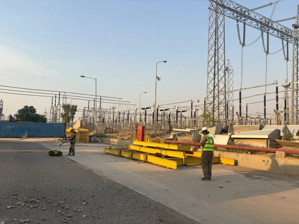 Survey underway on the access road through the station, with the switchyard gantries behind