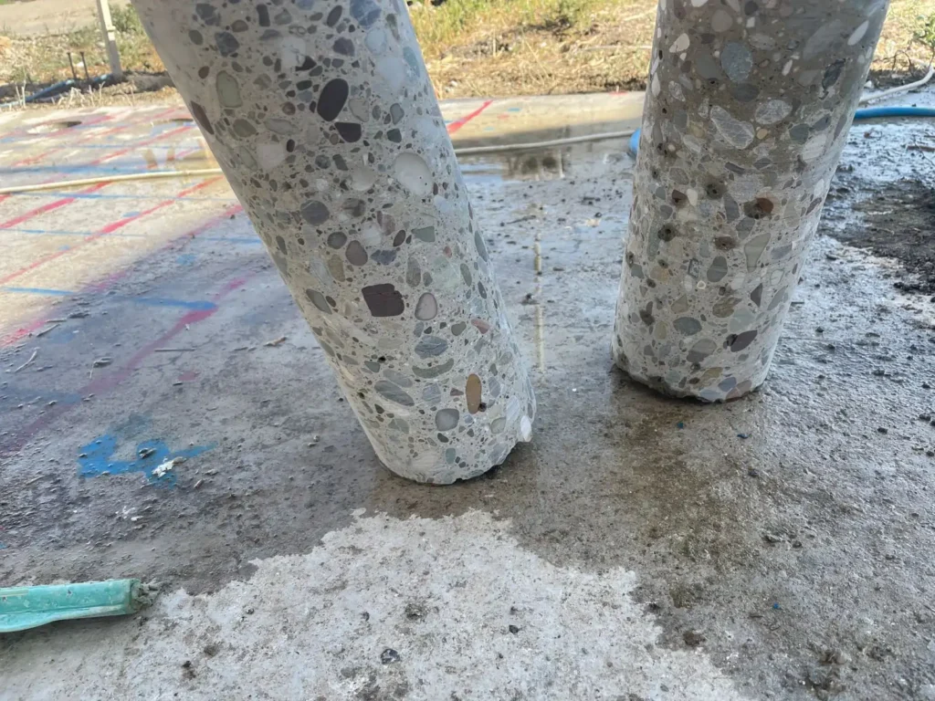 Two extracted concrete cores standing on the surveyed slab